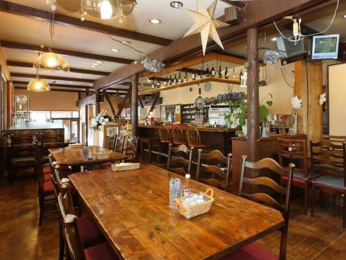 a restaurant with wooden tables and chairs and a bar at プライベートサウナがあるGuestHouseレビッキ【水上駅】より徒歩10分【水上IC】より車7分 in Minakami