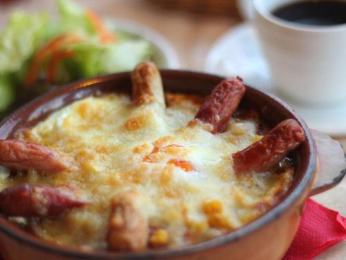 a bowl of food with sausage in a soup at プライベートサウナがあるGuestHouseレビッキ【水上駅】より徒歩10分【水上IC】より車7分 in Minakami