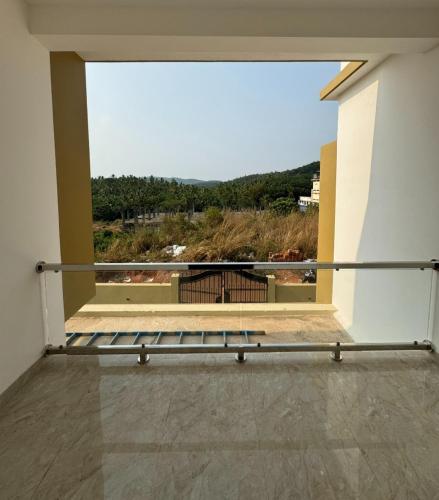 a balcony with a view of a window with a bench at Oasia homestay in Chāvasseri