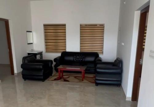 sala de estar con 2 sillas y mesa de centro en Oasia homestay, en Chāvasseri