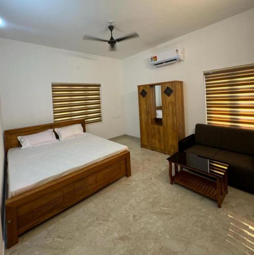 1 dormitorio con 1 cama y 1 sofá en Oasia homestay, en Chāvasseri