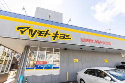 a store with a car parked in front of it at 琉球モダンスタイルの那覇の閑静な隠れ家 駅まで徒歩圏内の好立地 1階 in Kume
