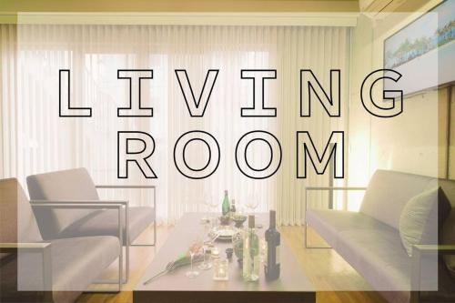 a living room with a sign that reads living room at 琉球モダンスタイルの那覇の閑静な隠れ家 駅まで徒歩圏内の好立地 1階 in Kume