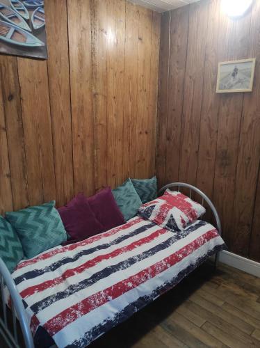 uma cama com uma colcha num quarto em Enchanté ! Chambres d'hôtes Brocéliande em Mauron