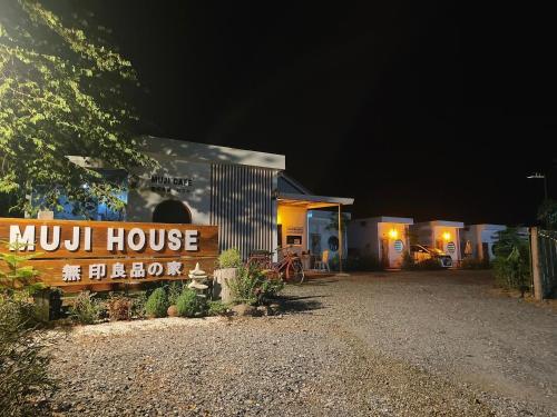 a munk house at night with a sign in front at Muji House Resort in Non Sang