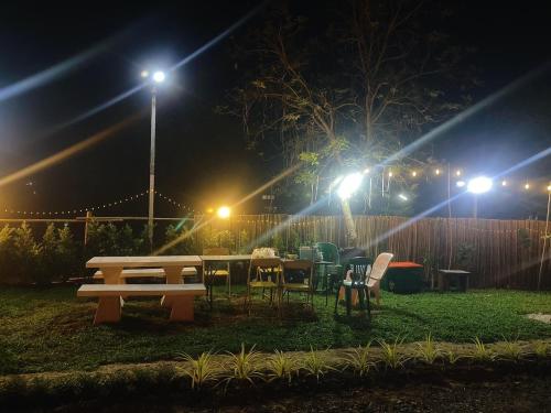 a picnic table and chairs at night with lights at Muji House Resort in Non Sang