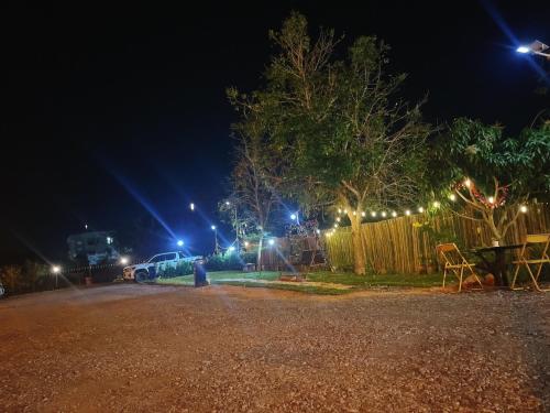 a parking lot at night with lights on a fence at Muji House Resort in Non Sang
