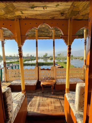 - un kiosque avec des lits et une vue sur l'eau dans l'établissement Houseboat Wild Rose, à Srinagar