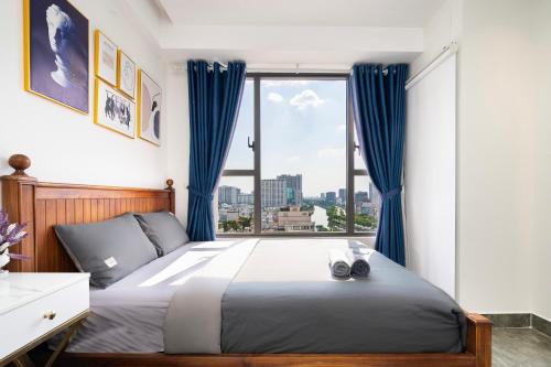 a bedroom with a large bed with a large window at Olala SaiGon Apartment - Millennium Tower in Ho Chi Minh City