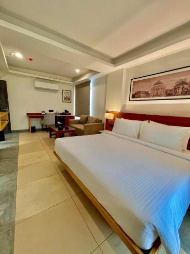 a bedroom with a large bed and a living room at Best Western Maharani Bagh New Delhi in New Delhi