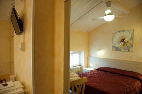 una camera con letto e ventilatore a soffitto di Antico Albergo a Negrar