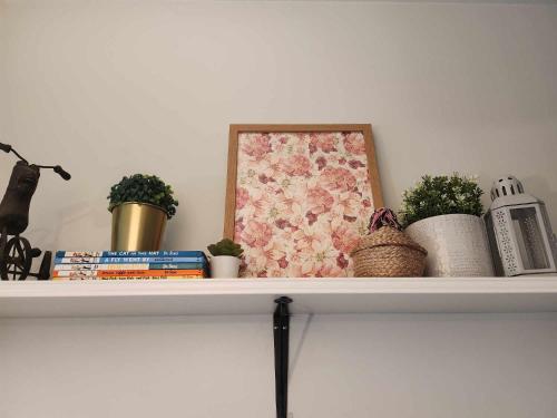 a shelf with plants and a picture on it at My Humble Abode at Shore 3 in Manila