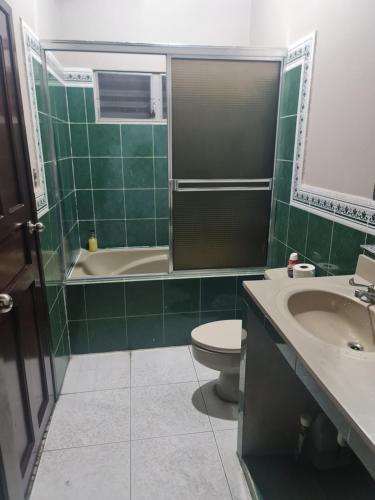 a bathroom with a toilet and a tub and a sink at Familiar y Acogedor in San Pedro Sula