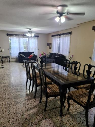 Familiar y Acogedor في سان بيدرو سولا: غرفة معيشة مع طاولة وكراسي وأريكة