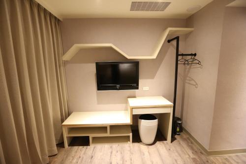 a room with a desk with a tv on the wall at Central Hotel in Zhongli