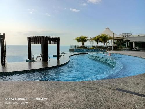 een zwembad met de oceaan op de achtergrond bij FR Studio Seaview Imperium Residence in Kuantan