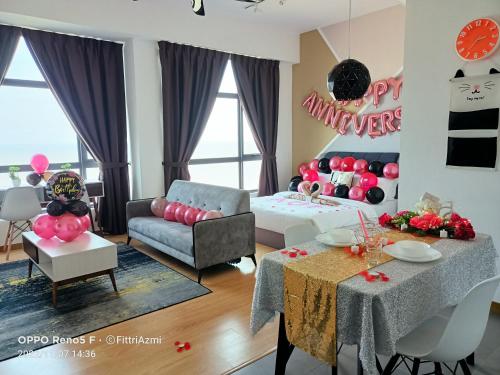 een woonkamer met roze ballonnen aan de muur bij FR Studio Seaview Imperium Residence in Kuantan