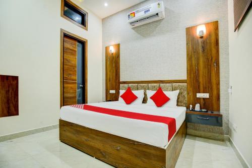 a bedroom with a large bed with red pillows at Super OYO Flagship Hotel Elista in Zirakpur
