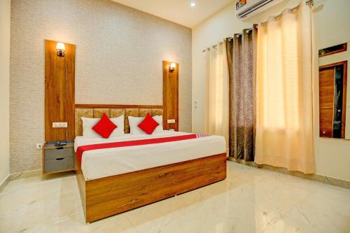 a bedroom with a large bed with red pillows at Flagship Hotel Elista in Zirakpur