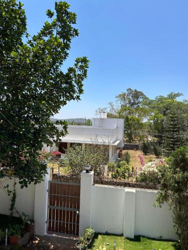 a white fence in front of a house at Sapphire Stayss in Yelagiri