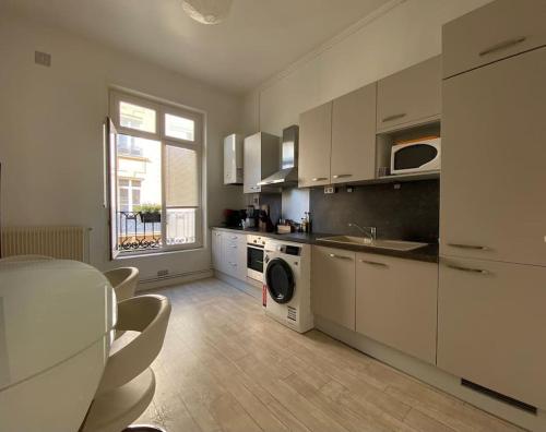 une cuisine avec des armoires blanches, un évier et un lave-vaisselle dans l'établissement The Maiden's, à Rouen