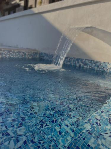 a water fountain in a swimming pool at Rancho los olivos Habitaciones Campestres in San Miguel de Allende