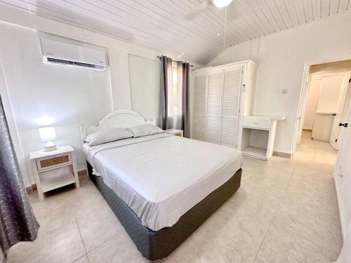 a bedroom with a large bed in a white room at Beach Walk in Saint James