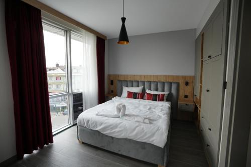 a bedroom with a bed with white sheets and a window at Dream house 22 in Istanbul