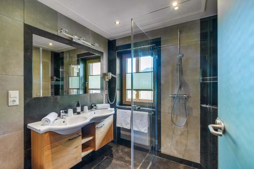 a bathroom with a sink and a shower at Apparthotel Talhof, Restaurant, Pool und Spa in Oberau