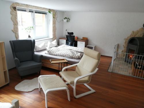 a living room with a bed and two chairs at Ferienwohnung Hecht - Relax or work in nature in Wolfegg