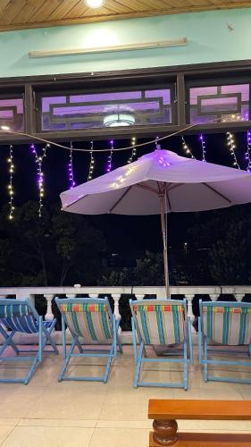 two chairs and an umbrella on a patio at Homestay Vân Đức Cù Lao Chàm in Tân Hiệp