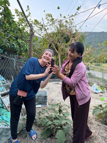 two women taking a picture of a woman with a camera at Homestay Vân Đức Cù Lao Chàm in Tân Hiệp
