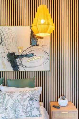 a bedroom with a bed and a yellow lamp at Newly renovated 4 bedroom home in Newport with Pittwater views in Newport