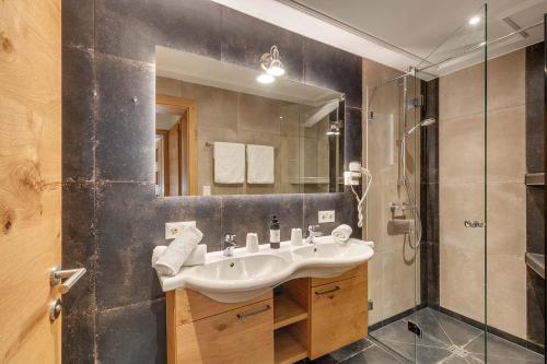 a bathroom with a sink and a shower at Apparthotel Talhof, Restaurant, Pool und Spa in Oberau