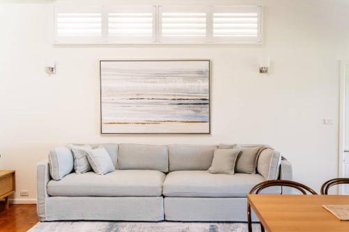 a living room with a couch and a table at Newly renovated 4 bedroom home in Newport with Pittwater views in Newport