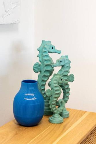 a green statue next to a blue vase on a table at Newly renovated 4 bedroom home in Newport with Pittwater views in Newport