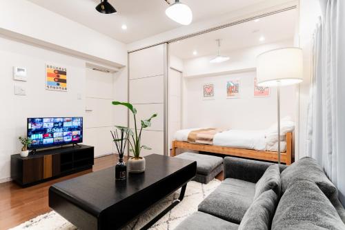 a living room with a couch and a bed at SAKURA Residence目黒駅前 in Tokyo