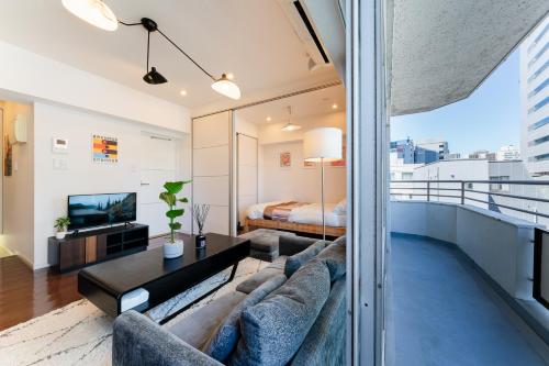 a living room with a couch and a bed at SAKURA Residence目黒駅前 Standard in Tokyo