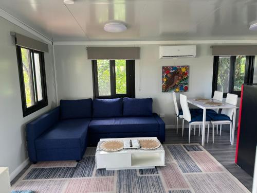 a living room with a blue couch and a table at Country Tracks in Willowbank