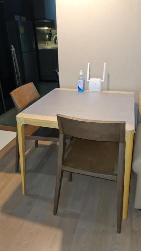 a table and a chair with a bottle of water on it at 1BR Thonglor , Fast WiFi , Near Samitivej , Nightlife in Klong Toi