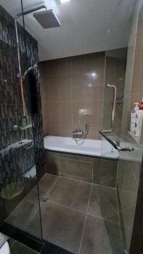 a bathroom with a shower and a bath tub with a glass door at 1BR Thonglor , Fast WiFi , Near Samitivej , Nightlife in Khlong Toei