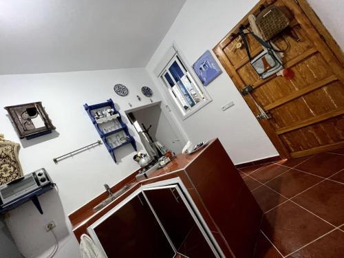 een keuken met een wastafel en een houten deur bij Perla Azul in Chefchaouene