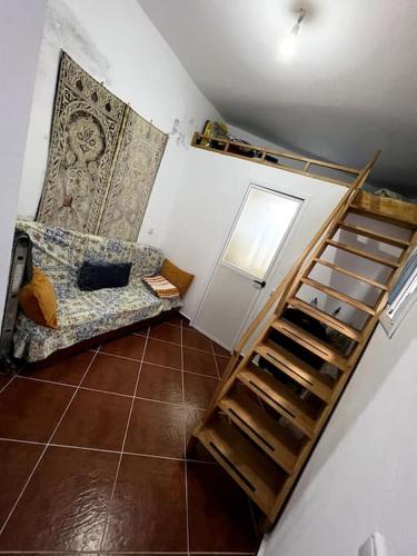una habitación con una escalera y un sofá en una habitación en Perla Azul, en Chefchaouen