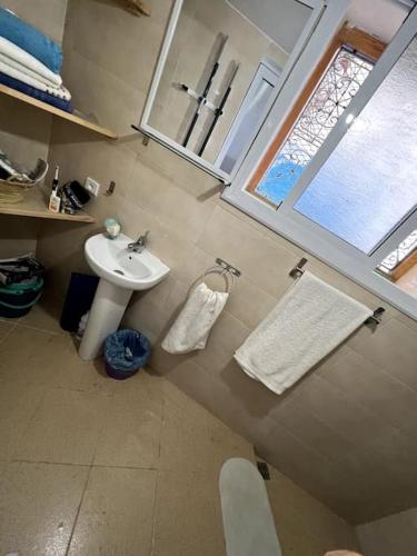 een kleine badkamer met een wastafel en een raam bij Perla Azul in Chefchaouene