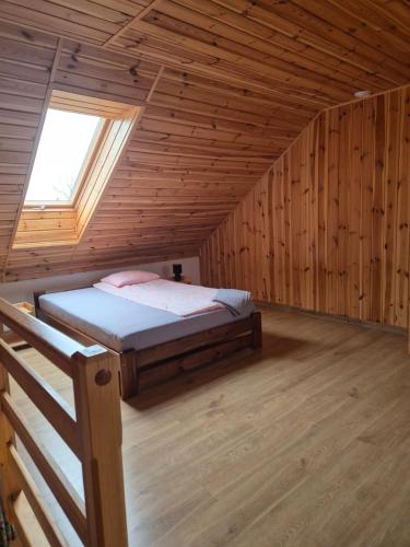 um quarto com uma cama num chalé de madeira em Siedlisko U Ani em Skrzynki