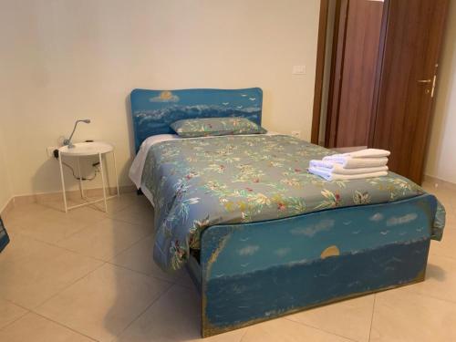 a bedroom with a blue bed and a table at Come Casa Tua in Carovigno