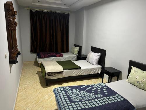 Zimmer mit 2 Betten und einem Fenster in der Unterkunft Appartement 6 meublée 2 étage in Oujda