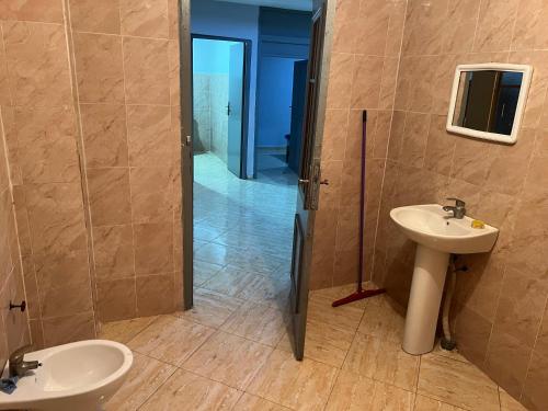 ein Badezimmer mit einem Waschbecken, einem WC und einem Spiegel in der Unterkunft Appartement 6 meublée 2 étage in Oujda