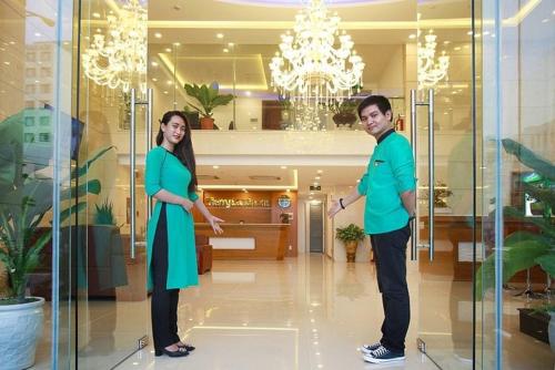 Ein Mann und eine Frau stehen in einer Lobby in der Unterkunft Tuong Vy Hotel in Ho-Chi-Minh-Stadt