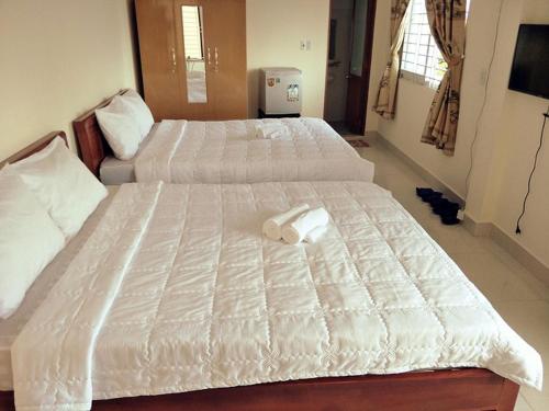 ホーチミン・シティにあるTuong Vy Hotelの大きな白いベッド(タオル付)